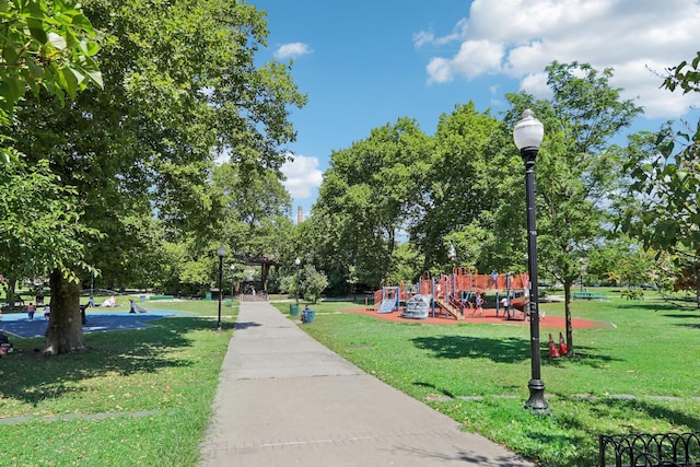 view of property's community with playground community and a yard