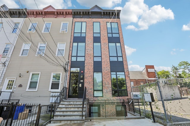 view of front facade featuring fence and brick siding