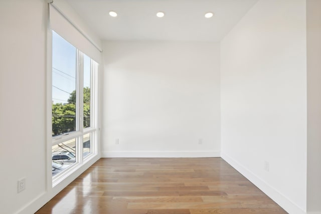 empty room featuring light wood-style floors, baseboards, and recessed lighting