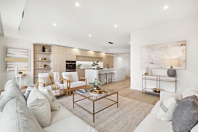 living room with light wood finished floors, baseboards, and recessed lighting