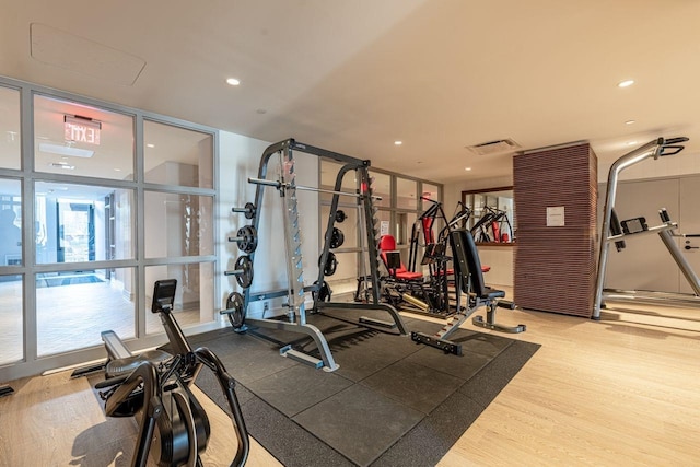 workout area with expansive windows and hardwood / wood-style flooring