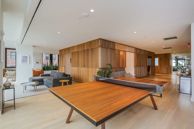 rec room featuring wooden walls and light hardwood / wood-style flooring