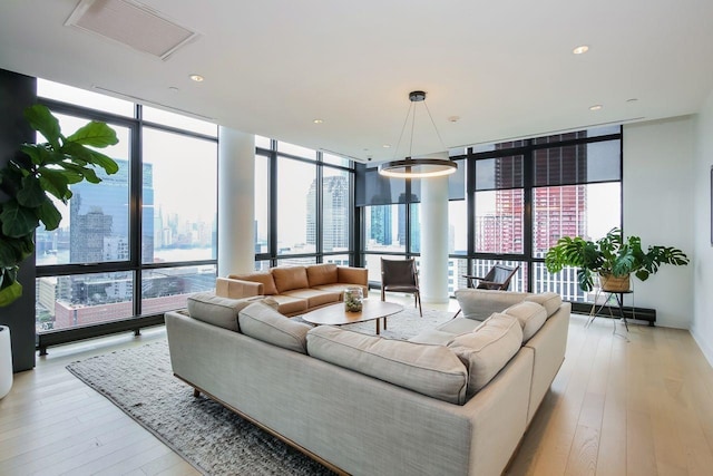 living room featuring a wall of windows and light hardwood / wood-style floors