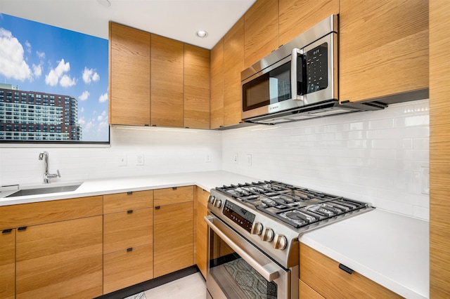 kitchen with appliances with stainless steel finishes, tasteful backsplash, and sink