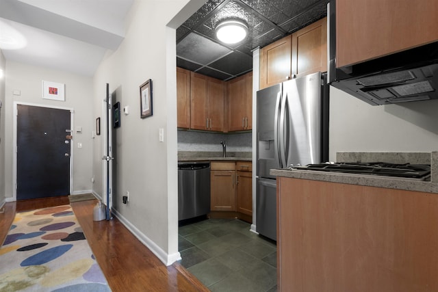 187 Wayne St Unit C405, Jersey City, NJ 07302 - kitchen featuring stainless steel appliances, range hood, dark wood-type flooring, and brown cabinetry