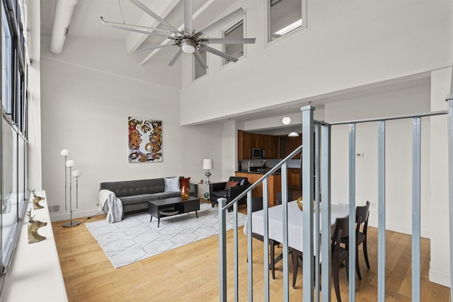 300 Communipaw Ave Unit 219, Jersey City, NJ 07304 - living room with light wood-type flooring, ceiling fan, a high ceiling, and stairs