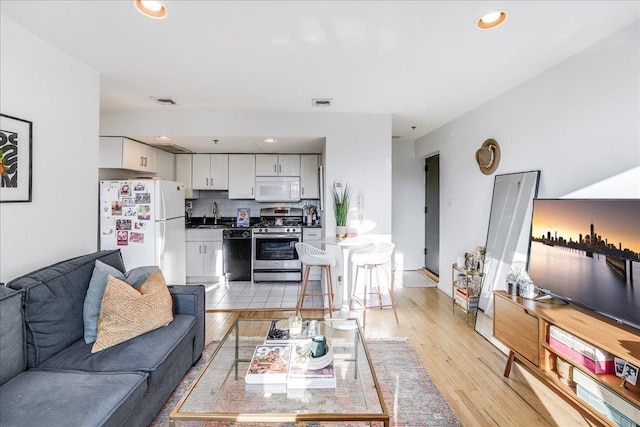 living room with light hardwood / wood-style flooring and sink