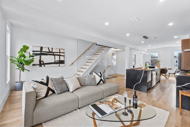 living room featuring sink and light hardwood / wood-style flooring