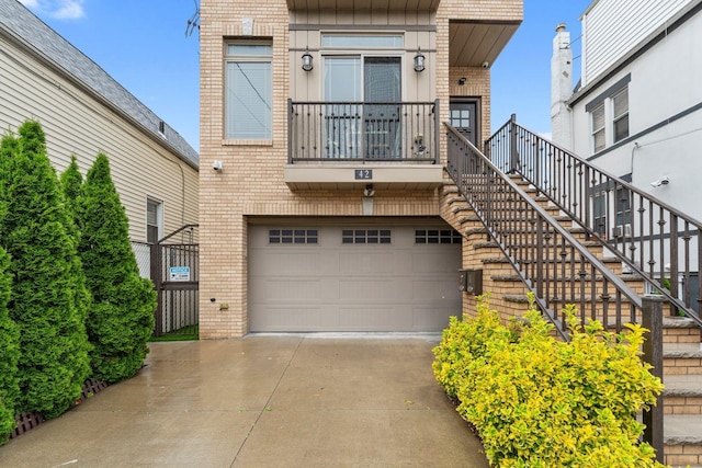 42 Grace St Unit 2A, Jersey City, NJ 07307 - view of front of house featuring brick siding, concrete driveway, an attached garage, and stairway