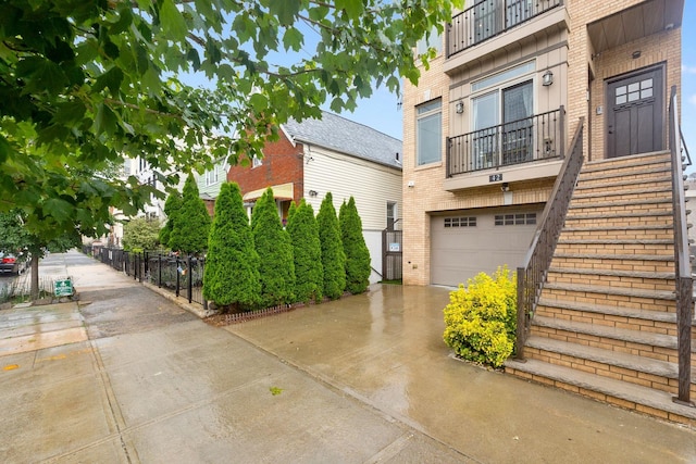 42 Grace St Unit 2A, Jersey City, NJ 07307 - view of home's exterior featuring brick siding, concrete driveway, a garage, and stairs