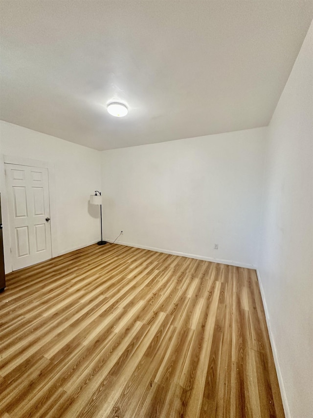 unfurnished room with baseboards and light wood finished floors