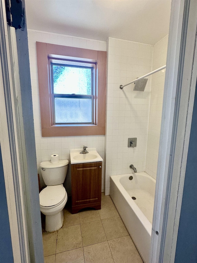 full bath with tile patterned floors, toilet, shower / tub combination, tile walls, and vanity