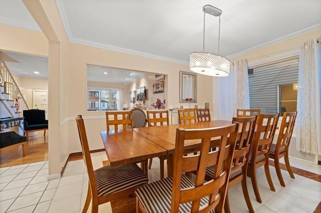 dining space featuring light tile patterned floors and crown molding