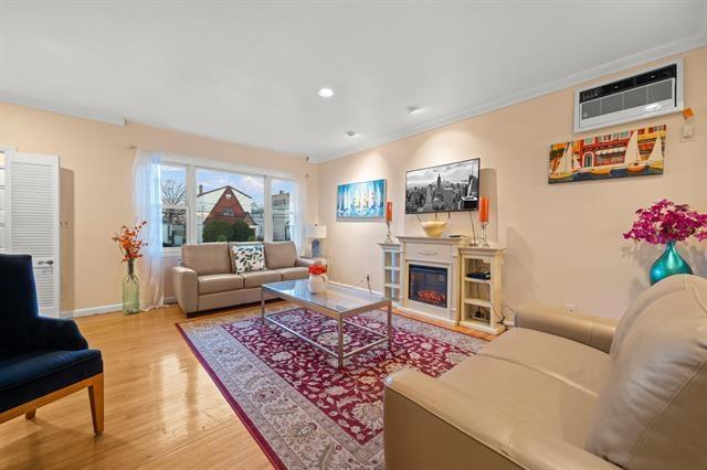 living room featuring light hardwood / wood-style flooring and an AC wall unit