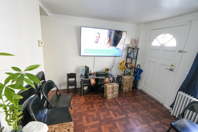 foyer entrance featuring radiator and dark parquet floors