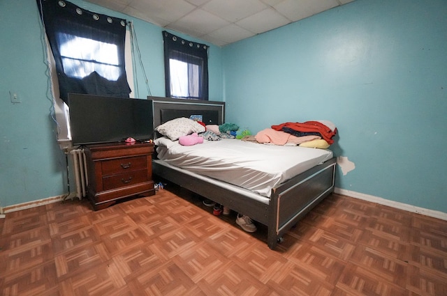 bedroom featuring parquet floors and a paneled ceiling