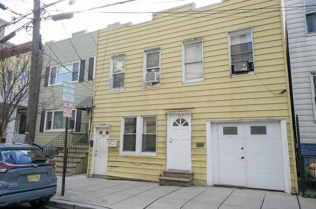 view of front facade featuring a garage and cooling unit