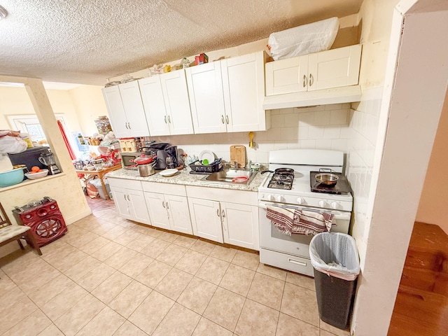 kitchen with white cabinetry, white gas stove, and decorative backsplash