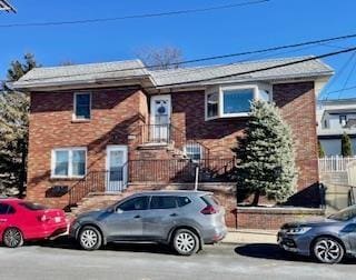 view of front of property featuring fence and brick siding