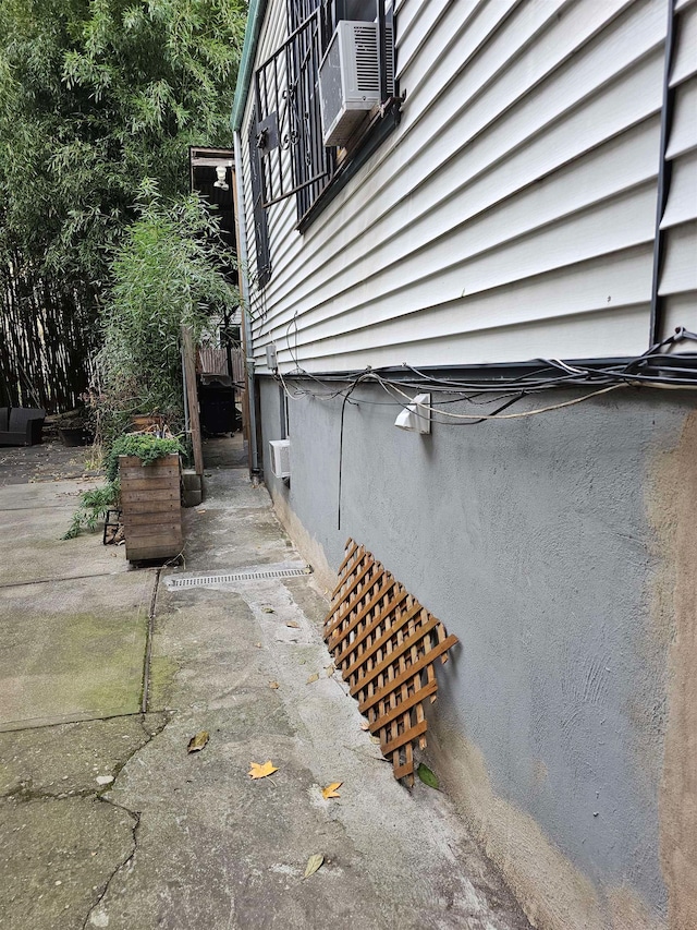 exterior space with cooling unit and a wall mounted AC