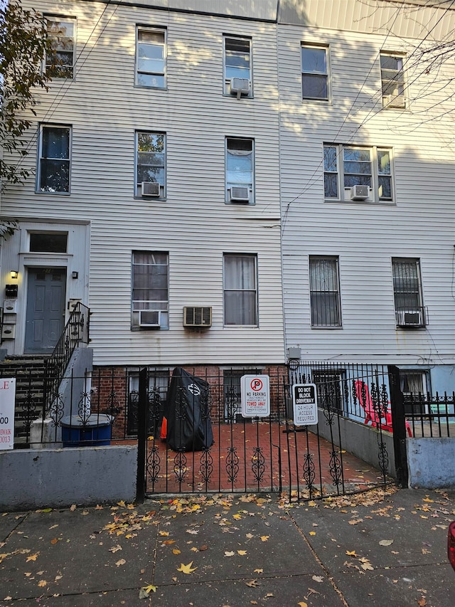 view of building exterior with cooling unit and a wall mounted air conditioner