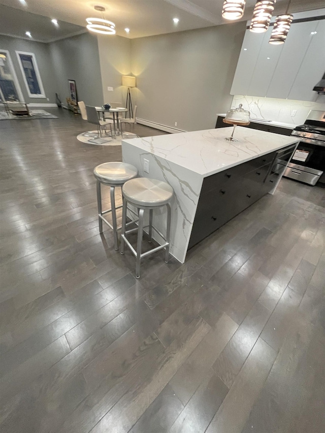 kitchen with a kitchen island, light stone countertops, gas stove, modern cabinets, and dark wood-style flooring