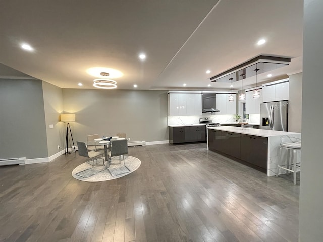 kitchen featuring light countertops, wall chimney exhaust hood, modern cabinets, and appliances with stainless steel finishes