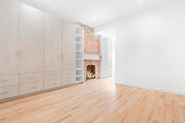 618 17th St, Union City, NJ 07087 - unfurnished living room featuring wood finished floors, built in shelves, and a brick fireplace