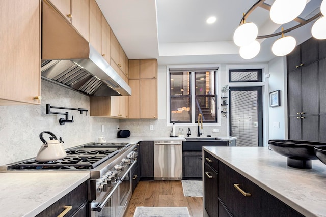 294 4th St, Jersey City, NJ 07302 - kitchen featuring a sink, light countertops, under cabinet range hood, light wood finished floors, and stainless steel appliances
