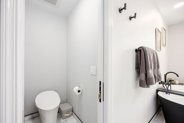 294 4th St, Jersey City, NJ 07302 - bathroom featuring toilet, a soaking tub, marble finish floor, and visible vents