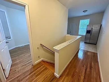 corridor with dark hardwood / wood-style flooring