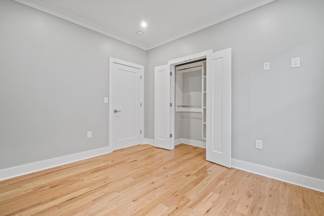 unfurnished bedroom featuring crown molding, a closet, and light wood-type flooring