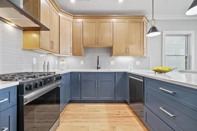 kitchen with stainless steel stove, tasteful backsplash, sink, hanging light fixtures, and wall chimney range hood