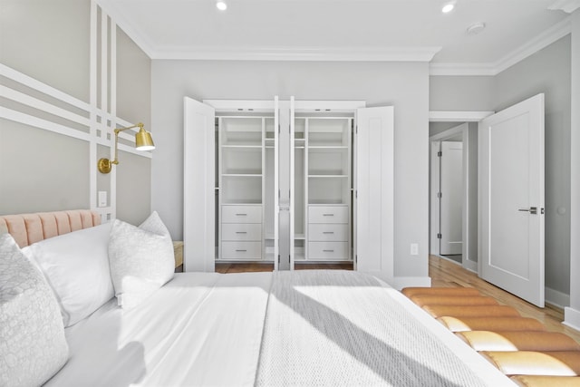 bedroom featuring hardwood / wood-style floors, ornamental molding, and a closet