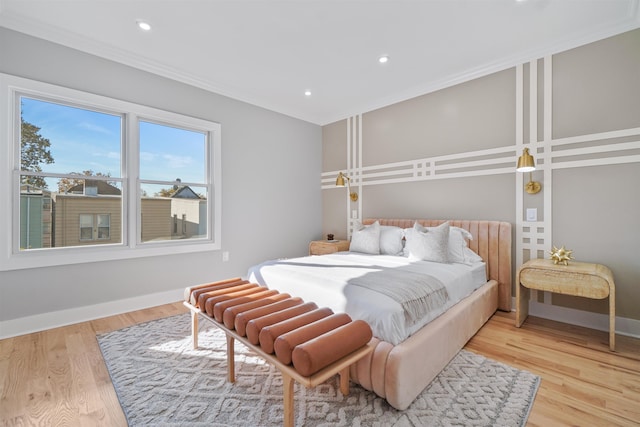 bedroom with ornamental molding and light hardwood / wood-style floors