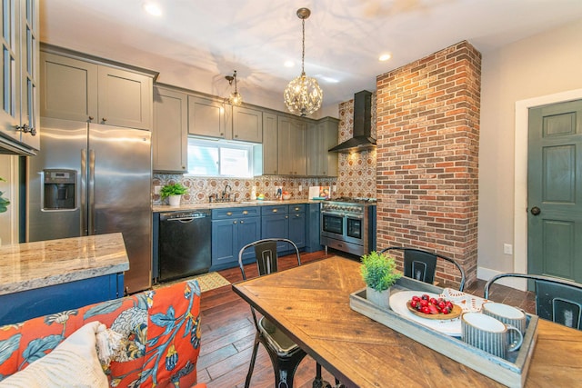 68 Osborne St, Glen Ridge, NJ 07028 - kitchen featuring wall chimney range hood, appliances with stainless steel finishes, dark wood-style floors, backsplash, and a chandelier