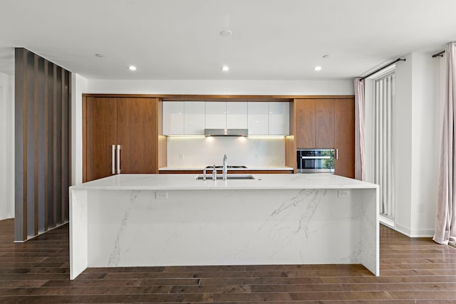 5 Washington Pl, Cliffside Park, NJ 07010 - kitchen featuring under cabinet range hood, modern cabinets, dark wood-type flooring, a spacious island, and stainless steel oven