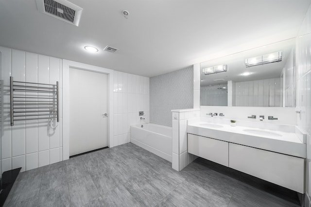 bathroom featuring double vanity, a bath, and visible vents
