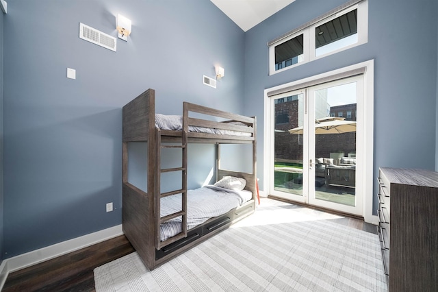 unfurnished bedroom with access to outside, baseboards, visible vents, and wood finished floors