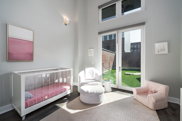 bedroom featuring access to outside, baseboards, and wood finished floors