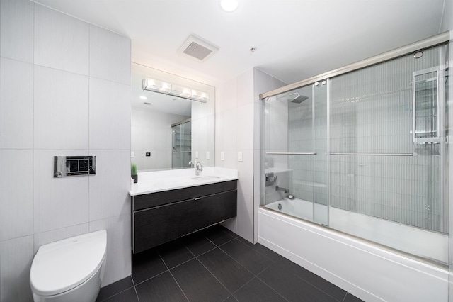 full bath featuring tile patterned flooring, vanity, toilet, enclosed tub / shower combo, and visible vents