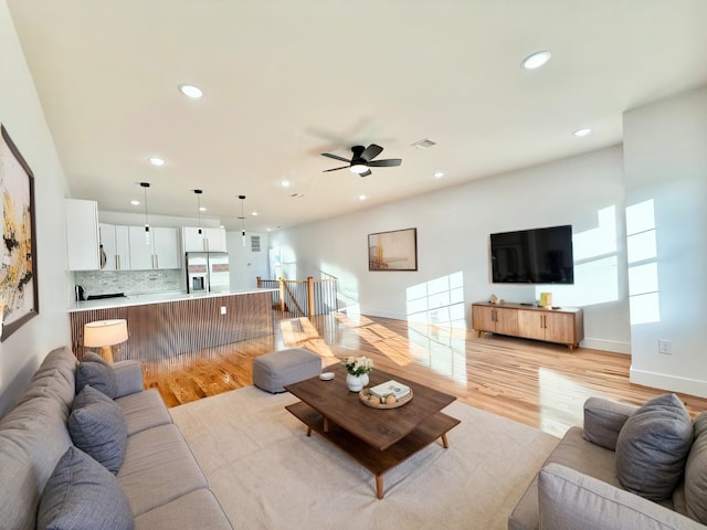 living room featuring light wood finished floors, plenty of natural light, visible vents, and recessed lighting