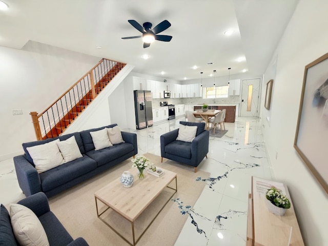 living area with ceiling fan, recessed lighting, baseboards, marble finish floor, and stairway