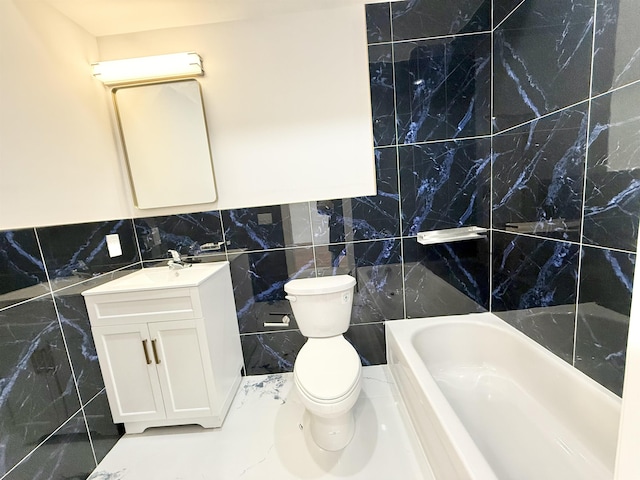 bathroom with toilet, a bathing tub, vanity, tile walls, and marble finish floor