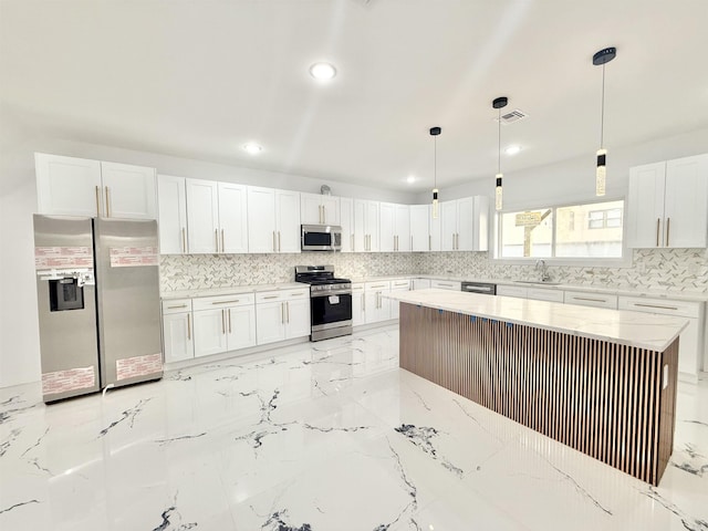 kitchen featuring hanging light fixtures, appliances with stainless steel finishes, and white cabinetry