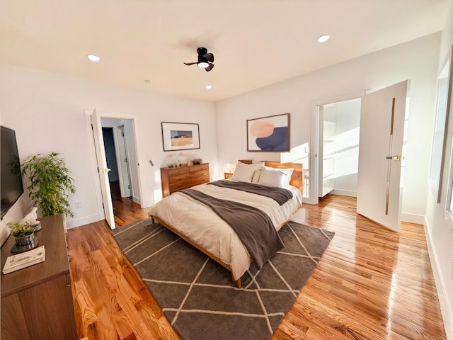 bedroom featuring baseboards, wood finished floors, and recessed lighting