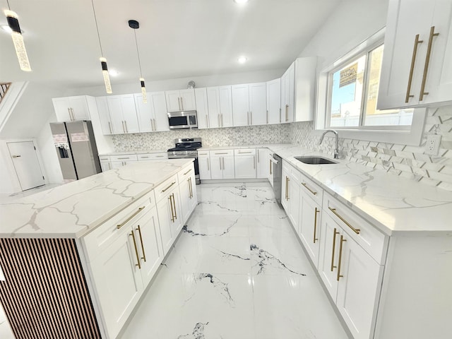 kitchen featuring appliances with stainless steel finishes, white cabinetry, a sink, and light stone counters