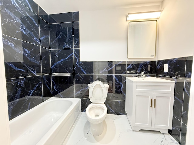 bathroom featuring toilet, marble finish floor, tile walls, and vanity