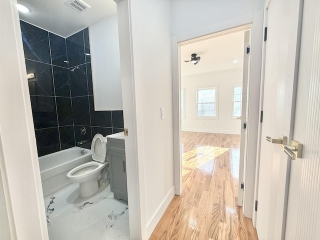 bathroom featuring baseboards, visible vents, toilet, wood finished floors, and vanity