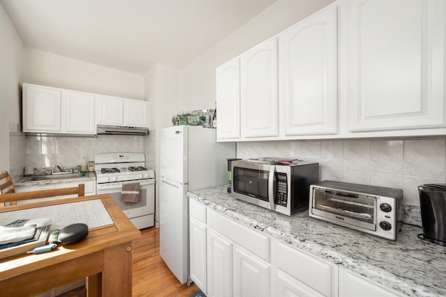 kitchen featuring light stone counters, white appliances, light hardwood / wood-style flooring, and white cabinets